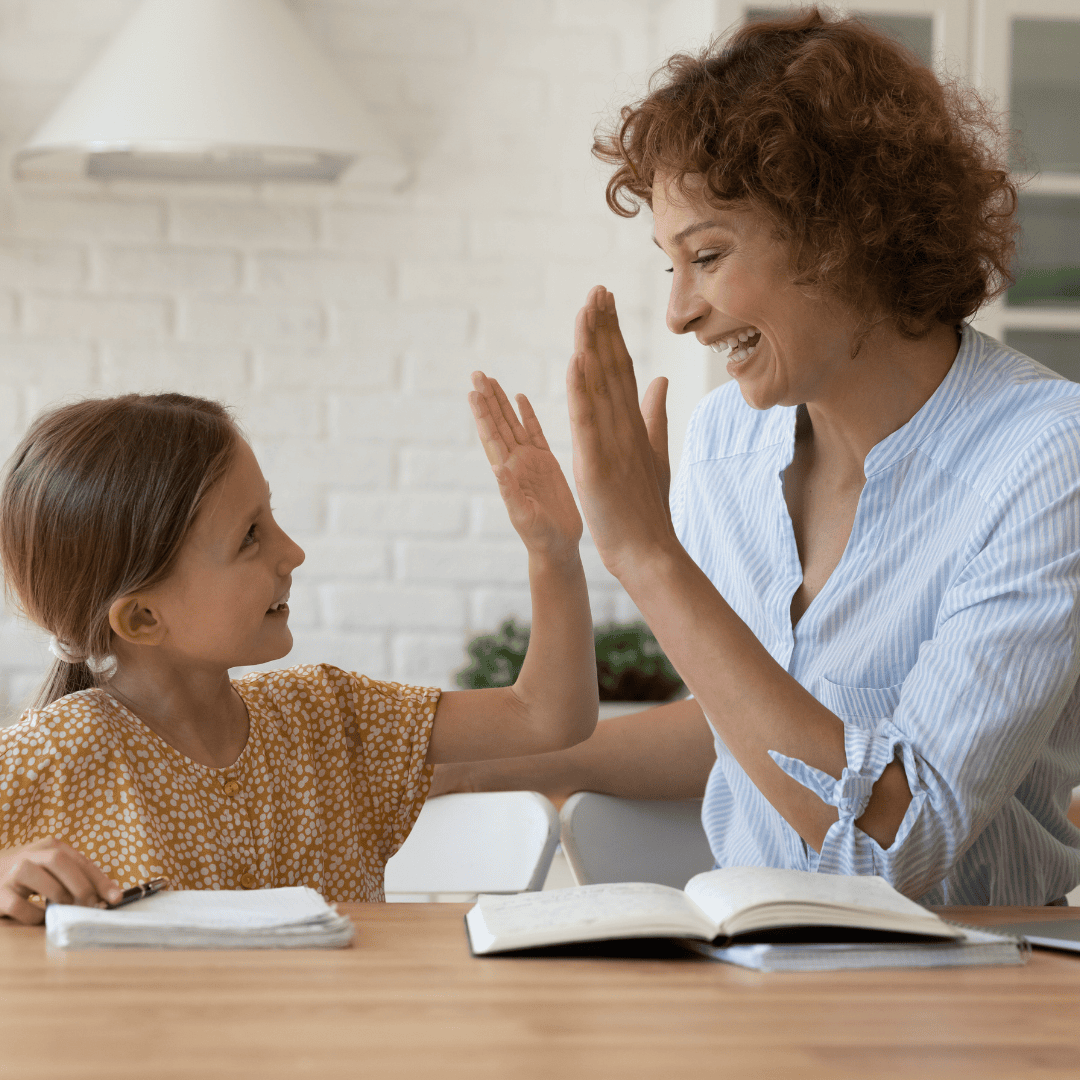 一个小女孩高兴地和她的治疗师击掌。
