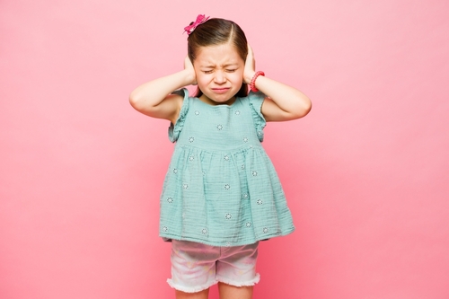 Sensory disorder, too noisy. Girl covering her ears