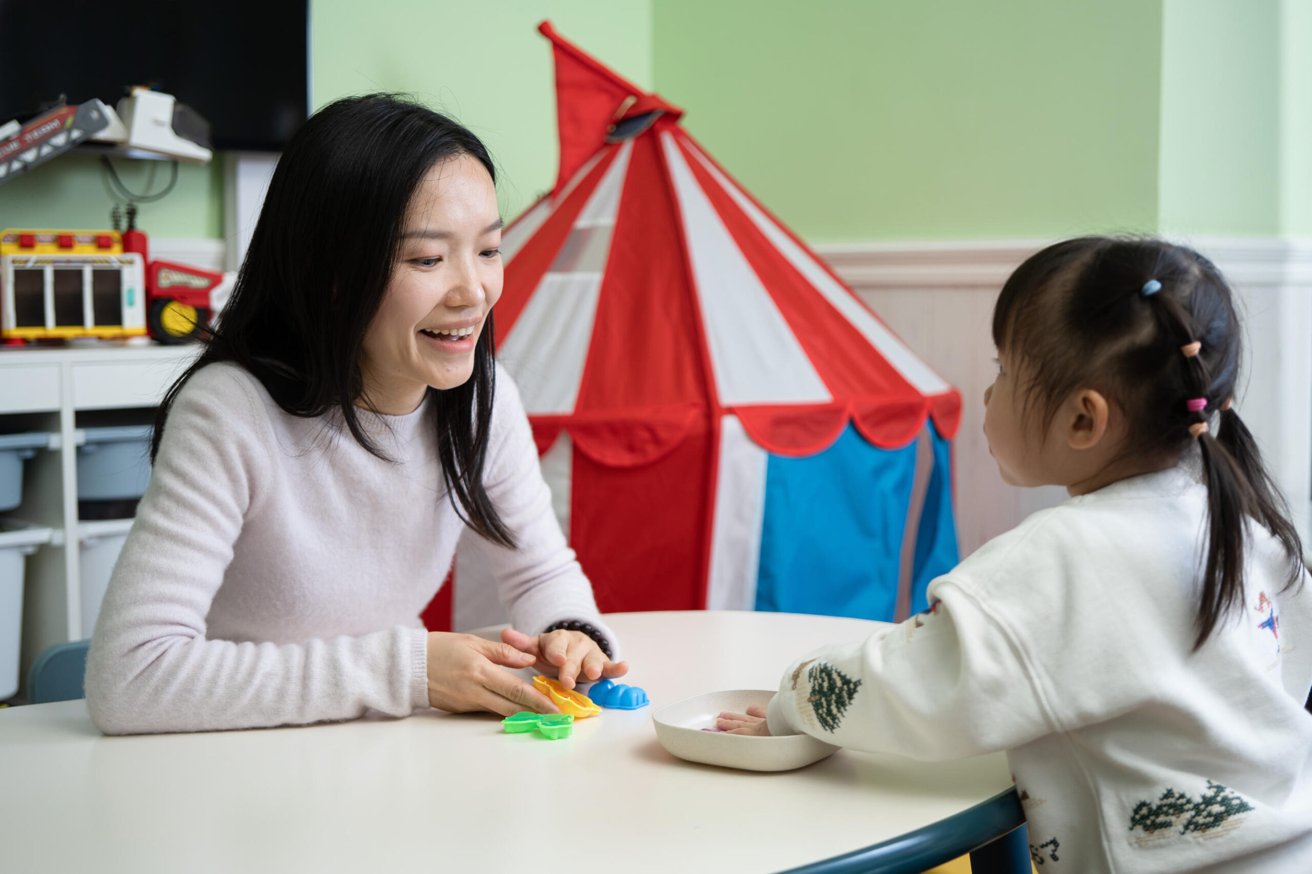 ABA therapy one on one Ms Liao Min and a young girl